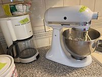 Overview of white KitchenAid Ultra Power mixer next to white Braun coffee maker on countertop