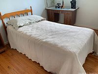 Full view of assembled twin bed with coverlet and pillow