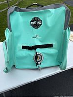 Front view of turquoise inflatable Bote beach chair showing brand logo, carrying handle, and black strap.