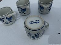 Four Blue Danube Japan tea cups placed in various orientations showing top, side, handle, and bottom markings