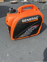 Left side view showing Generac logo on orange and black housing and top carry handle.