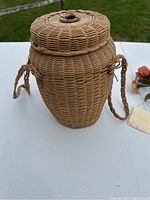 Front angle view of the handmade woven knitting basket showing lid and braided strap