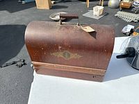 Wooden curved carrying case with handle and Singer logo decal visible on the front.