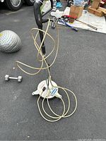 Full view of the power washer driveway surface cleaner attachment with coiled hose and handle.