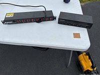 Two Gurley power switch units on a white table, one rack mountable with 8 switch-controlled outlets and the other a smaller 7 outlet unit.
