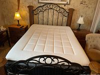 Straight-on view of assembled bed showing headboard, mattress, and footboard