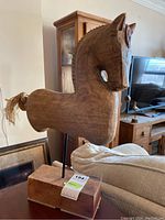 Full side view showing profile of carved wood horse figure mounted on wood block