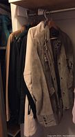 Six leather jackets visible hanging in closet in various colors, including light brown and white jackets.