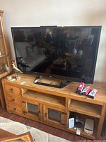 LG 54-inch TV on wooden console, showing full frontal view