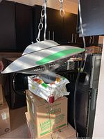 Side angle view focusing on the heat lamp's metal concave reflector and hanging chain mount.