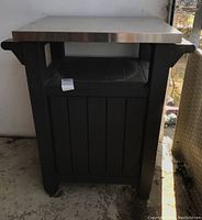 Outdoor portable island front view showing the metal top and resin base with open cabinet door.