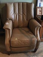 Front view of tan faux leather retro recliner chair with visible mark on seat cushion and padded arms