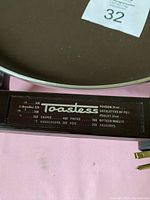 Close-up of the Toastess branded temperature control with a list of cooking temperature guidelines in French.