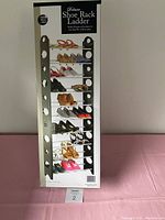 Photo of boxed 30 Pair Shoe Ladder shoe rack, showing front of packaging with image of assembled rack holding multiple pairs of shoes.