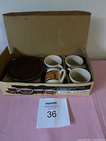 Set of four vintage demitasse coffee mugs with four matching saucers in original box, showing titles and condition.