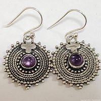 Close-up front view of the pair of sterling silver amethyst earrings showing intricate braided and beaded circular design with central amethyst stone and clover detail