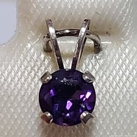 Close-up of the sterling silver amethyst pendant showing the purple faceted stone