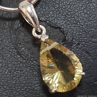 Close-up image of the pear-shaped citrine gemstone pendant set in sterling silver showing facets and stone clarity.