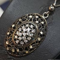 Close up of the sterling silver filigree pendant with cubic zirconia stones showing intricate design and cluster details.
