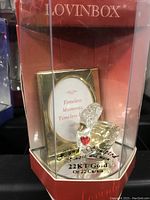 Front view of the Lovingbox crystal swan figurine inside clear display box showing gold inscriptions and heart detail.