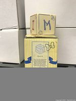 Photo of collectible block from front and side showing letter designs and packaging details