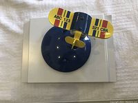 Top view of blue and yellow airplane-themed light fixture mounted on blue base.