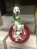 Disney 101 Dalmatians Christmas Magic collectible ornament showing the large Dalmatian with green scarf and two smaller puppies on a red sled.