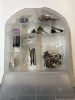 Organizer case open showing multiple compartments with assorted rotary tool accessory bits including sanding drums, wire brushes, and grinding stones