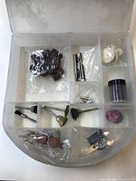 Photo of opened plastic storage case showing multiple compartments with assorted Mastercraft rotary tool bits and accessories, many in original plastic packaging.