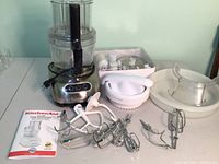 Full lot, including food processor base, attachments, manual, citrus press, and disc box.