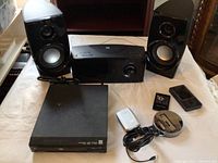 Front view of portable CD player with remote, speakers, and DVD player with cable and dock