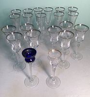 Set showing 11 champagne flutes and 8 matching glasses with silver rims, plus 2 tall stem glasses