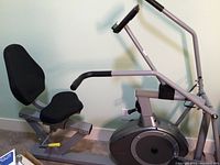 Side view of the recumbent exercise bike showing padded contoured seat with backrest and handlebars