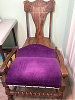 Front view of vanity bench chair with purple velvet upholstered seat and backrest, wooden arms and spiral turned legs visible