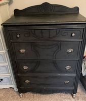 Front view of charcoal painted 4-drawer dresser with carved drawer details, metal knobs and pulls
