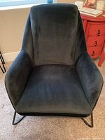 Front-facing view of navy velvet armchair showing seat, back, and metal sled base