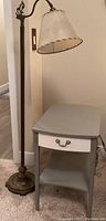 Side table next to vintage metal floor lamp showing standing height and overall size ratio