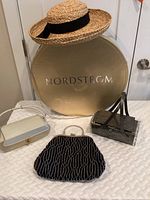 Wide view showing all handbags, straw hat on top of the Nordstrom hat box.