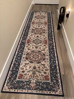 Full length view of the floral patterned runner rug laid out in hallway showing overall design and colors.