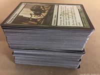 Stack of Magic the Gathering cards showing card edges and part of an Orzhov Syndicate card on top.