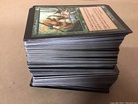 Stack of Magic the Gathering cards showing card backs and one visible front card.