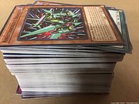 Stack of over 200 Yugioh cards showing card edges and some card faces; the top card is 'Anesthroket Dragon'.