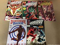 Photo of 5 Daredevil comic books arranged in two rows, showing vibrant covers with Daredevil characters including Bullseye and Daredevil versus Night Nurse issues.