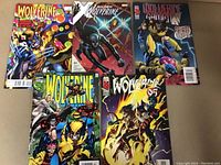 Five Wolverine comic books laid out in two rows showing covers.