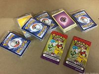 Photo of a lot containing eight sealed Pokémon trading card booster packs, six with classic blue backs and two with 'Match Battle' themed packaging featuring Pikachu and Treecko.