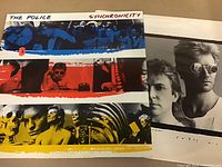 Front cover of The Police Synchronicity vinyl album featuring colored strip artwork and photos of band members.