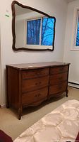 Full view of vintage wooden dresser with six drawers and mounted wooden framed mirror. Shows overall condition and style.