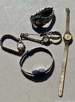 Five vintage ladies' wristwatches displayed together on a flat surface.
