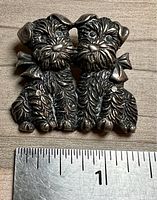 Front view of the silver Scottish Terrier dog pair pin with a ruler showing width of just under 1 inch.
