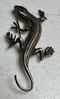 Top view showing full shape and detailed texture of salamander design on sterling silver pin/pendant